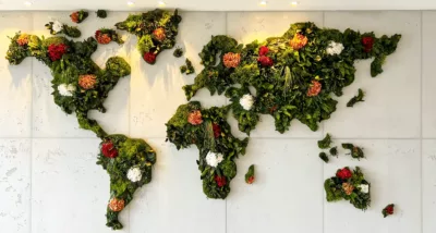 Weltkarte aus Pflanzen, Moos und Blumen auf weißen Untergrund