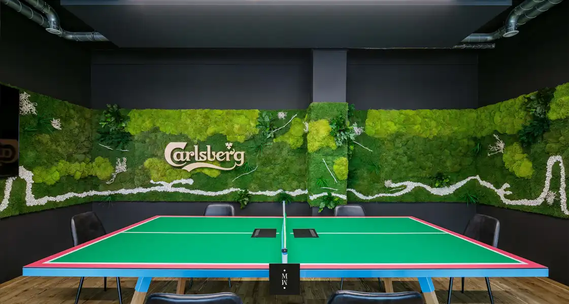 a table with a green table and chairs in front of a wall