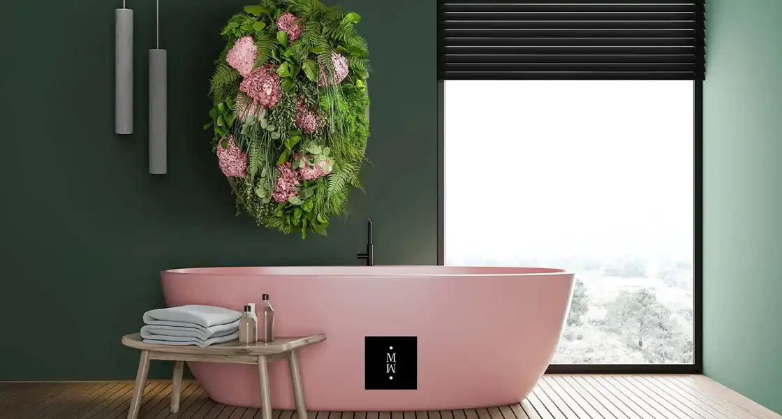 a pink bathtub with flowers on the wall
