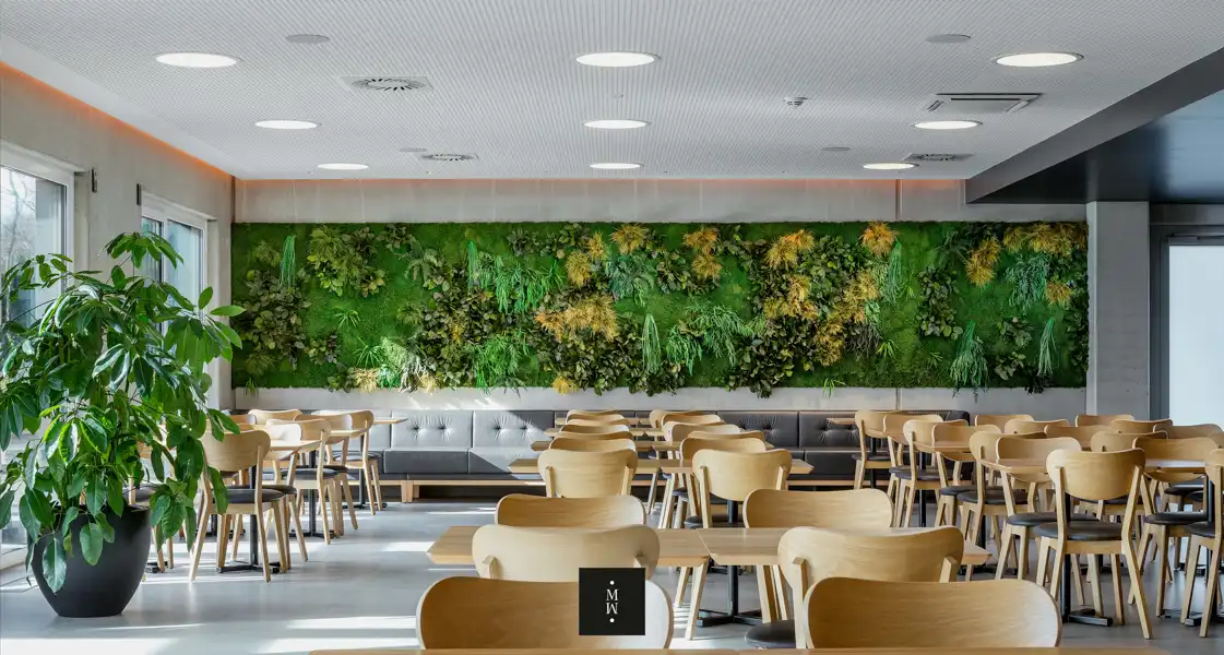 a room with tables and chairs and plants on the wall