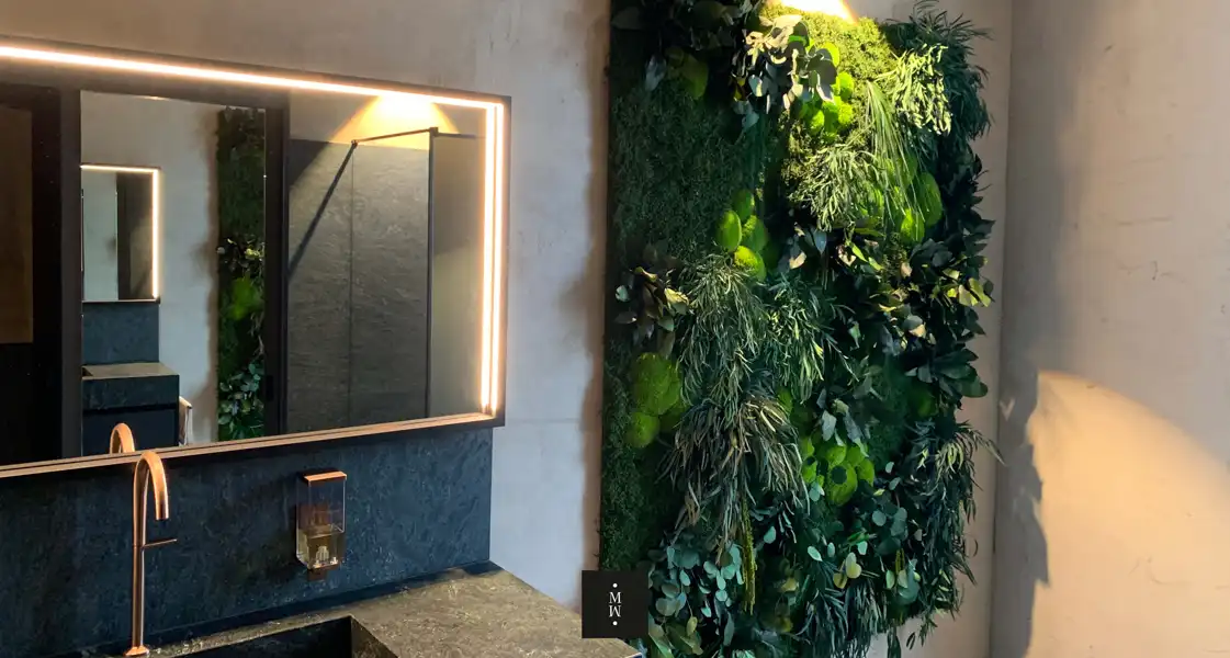 a green wall with plants and a mirror
