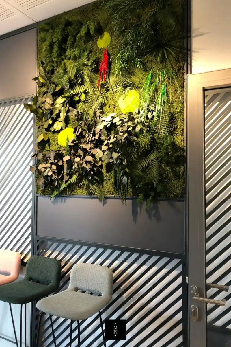 a wall with plants and chairs