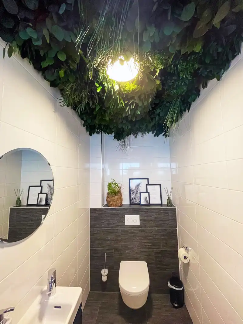a bathroom with plants on the ceiling