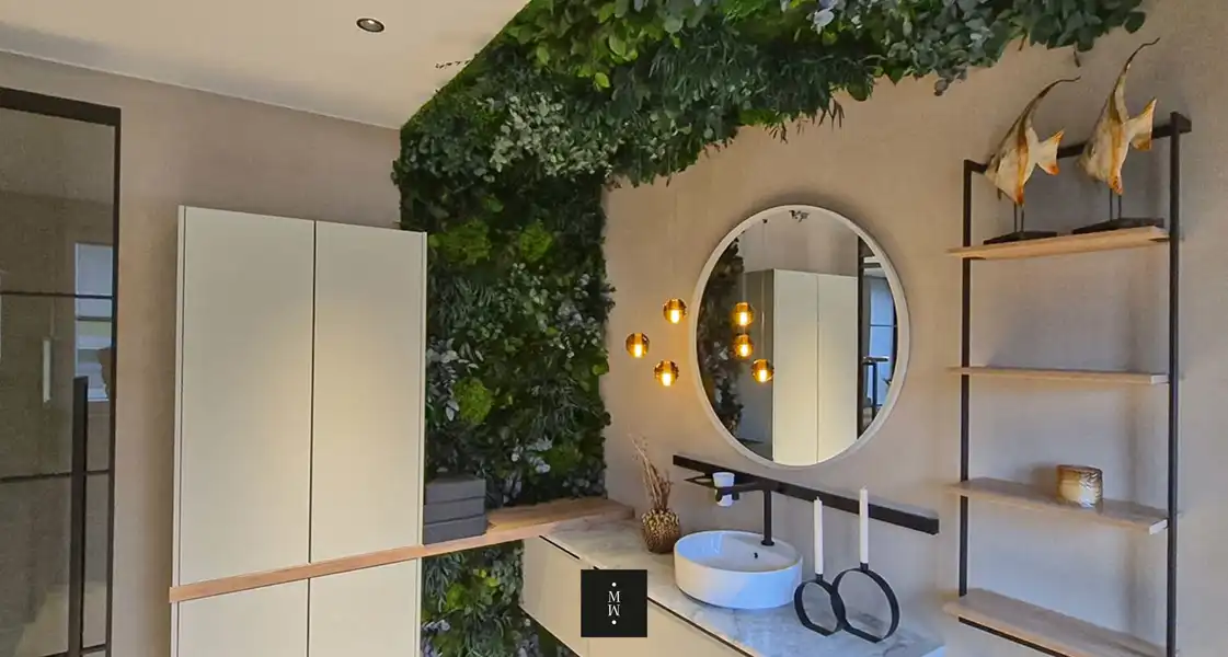 a bathroom with a round mirror and plants
