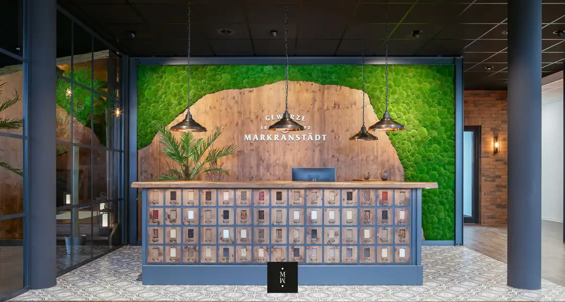 a reception desk with a green wall and lights
